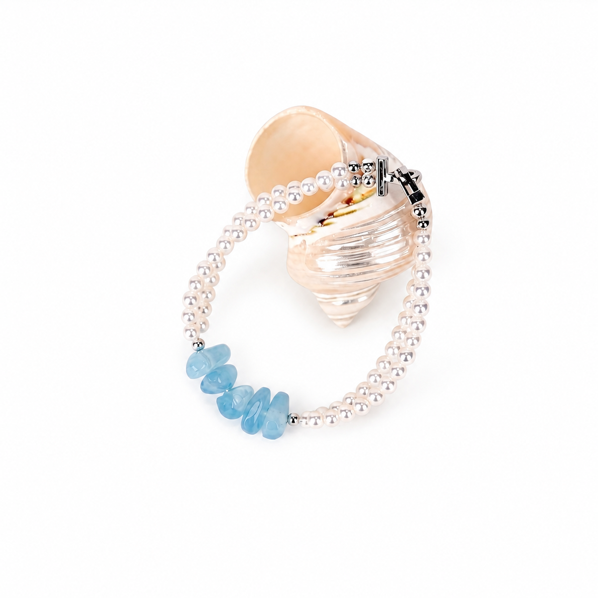 Chérie çv freshwater pearl and aquamarine bracelet beside a seashell