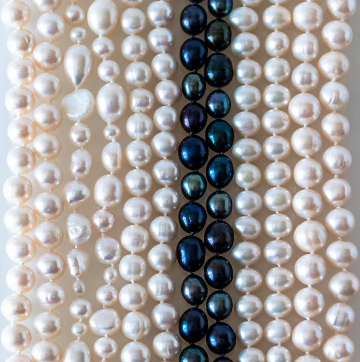 White baroque, round, and blue-dyed freshwater pearl strands threaded on silk