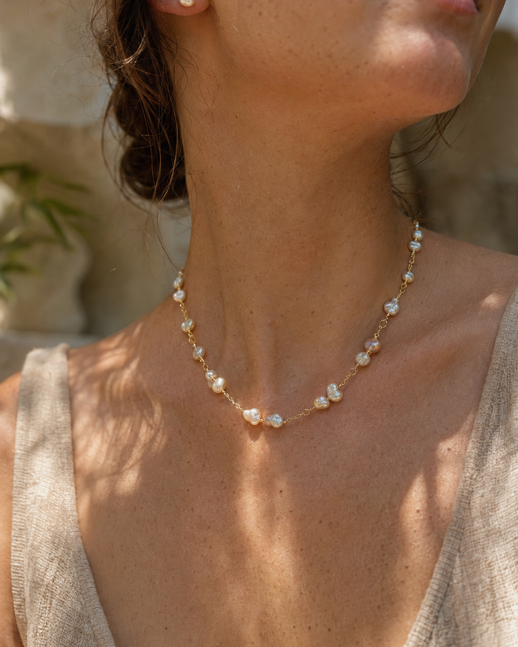 Woman wearing pearl jewelry in warm sunlight for Chérie çv Our Story