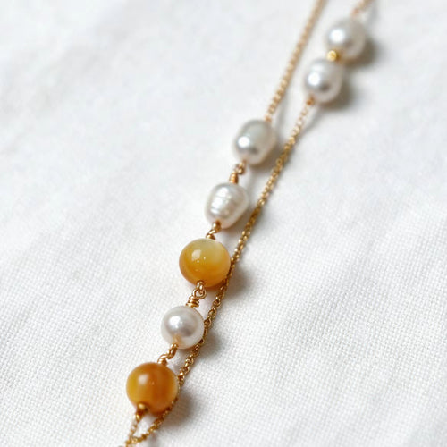 Asymmetrical freshwater pearl and golden-lip mother-of-pearl bead details on the Aurelia Necklace