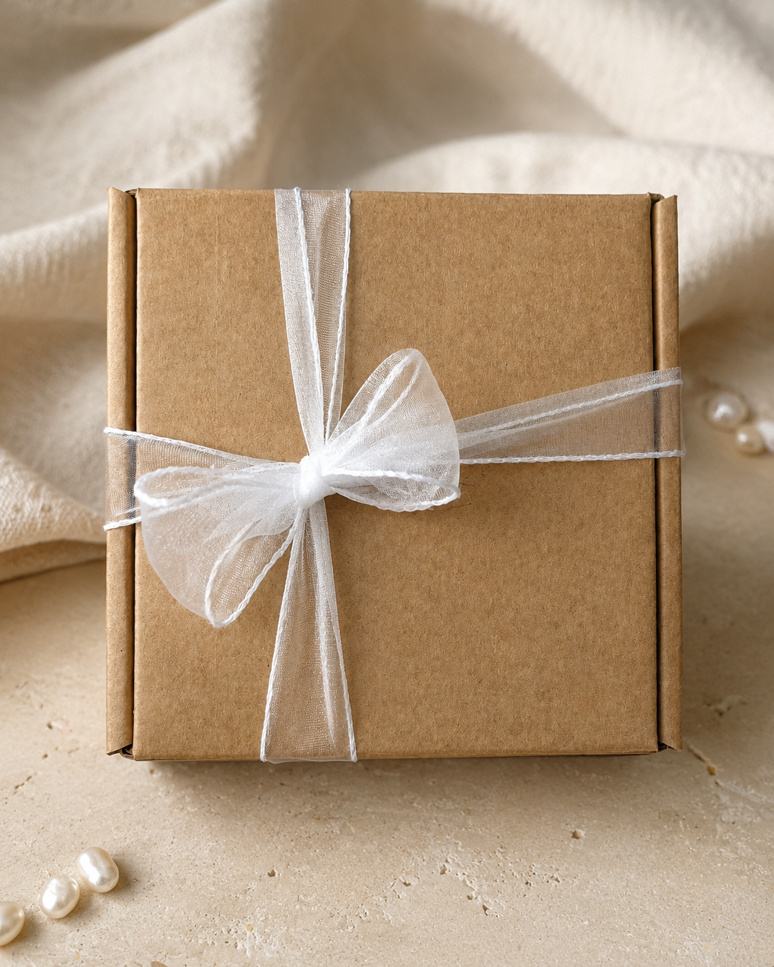 Chérie çv kraft jewelry gift box tied with an ivory organza ribbon
