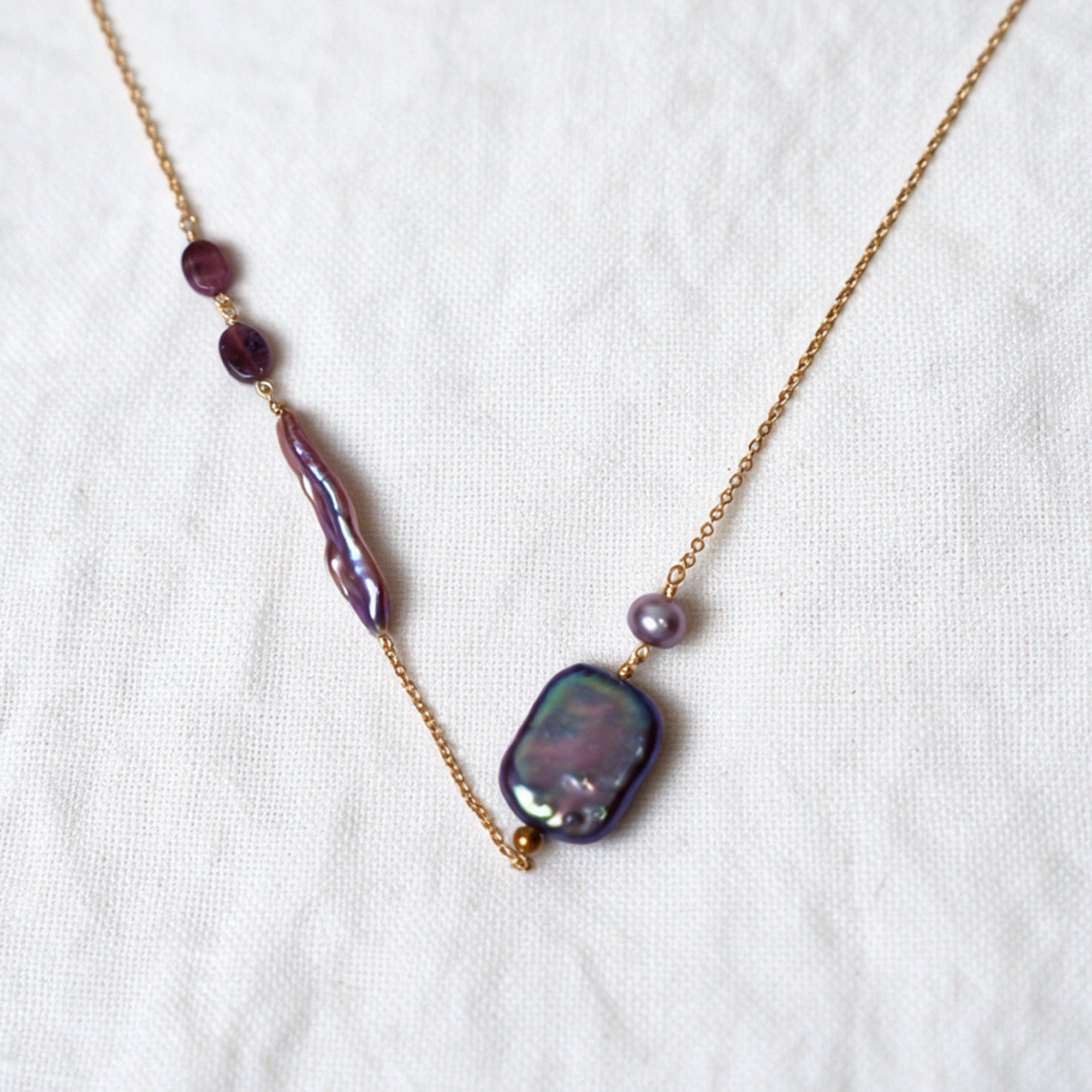 Iris asymmetrical necklace with purple tourmaline stones and two baroque pearls on a 14k gold-filled chain