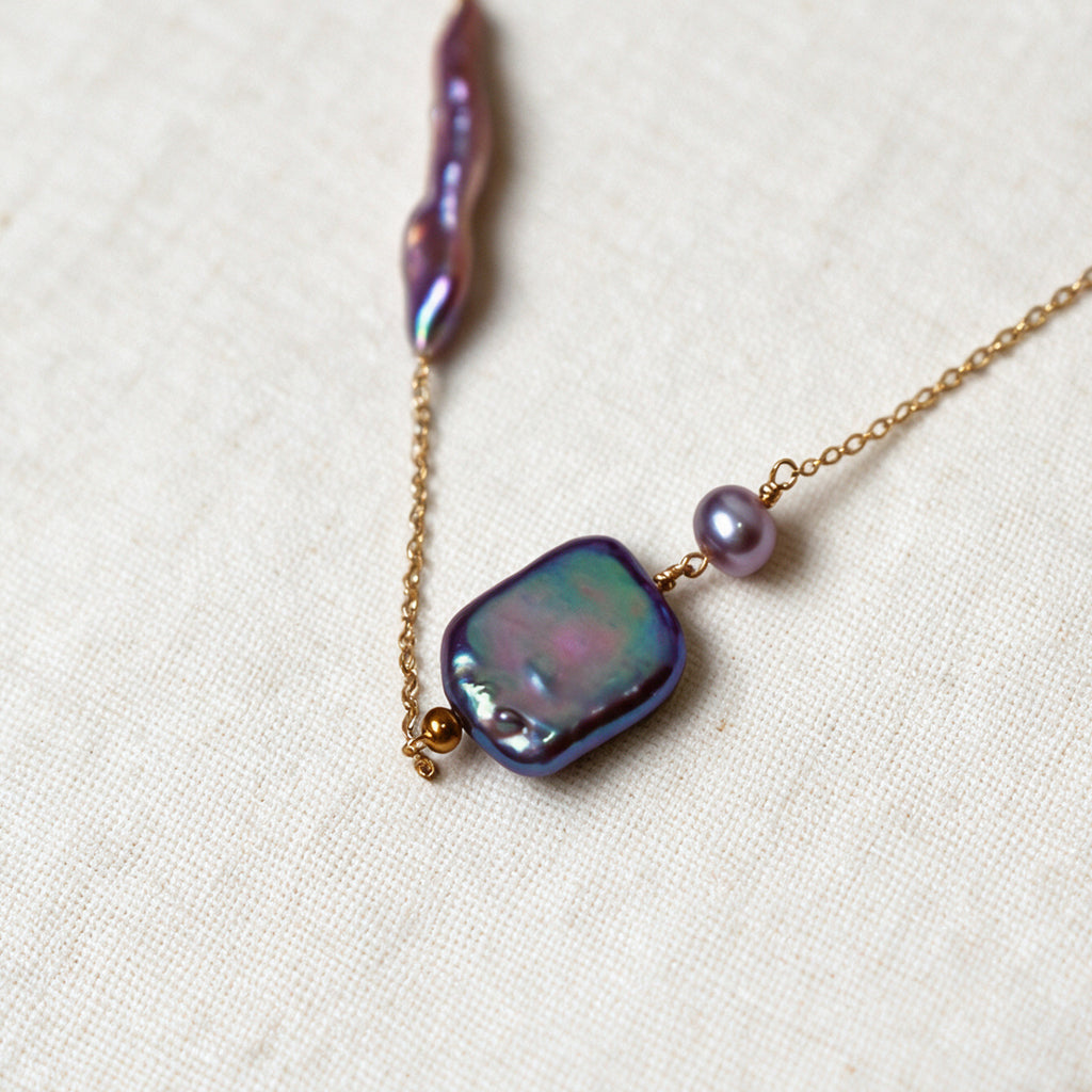 Close-up of the square iridescent baroque pearl and purple tourmaline detail on the Iris Necklace