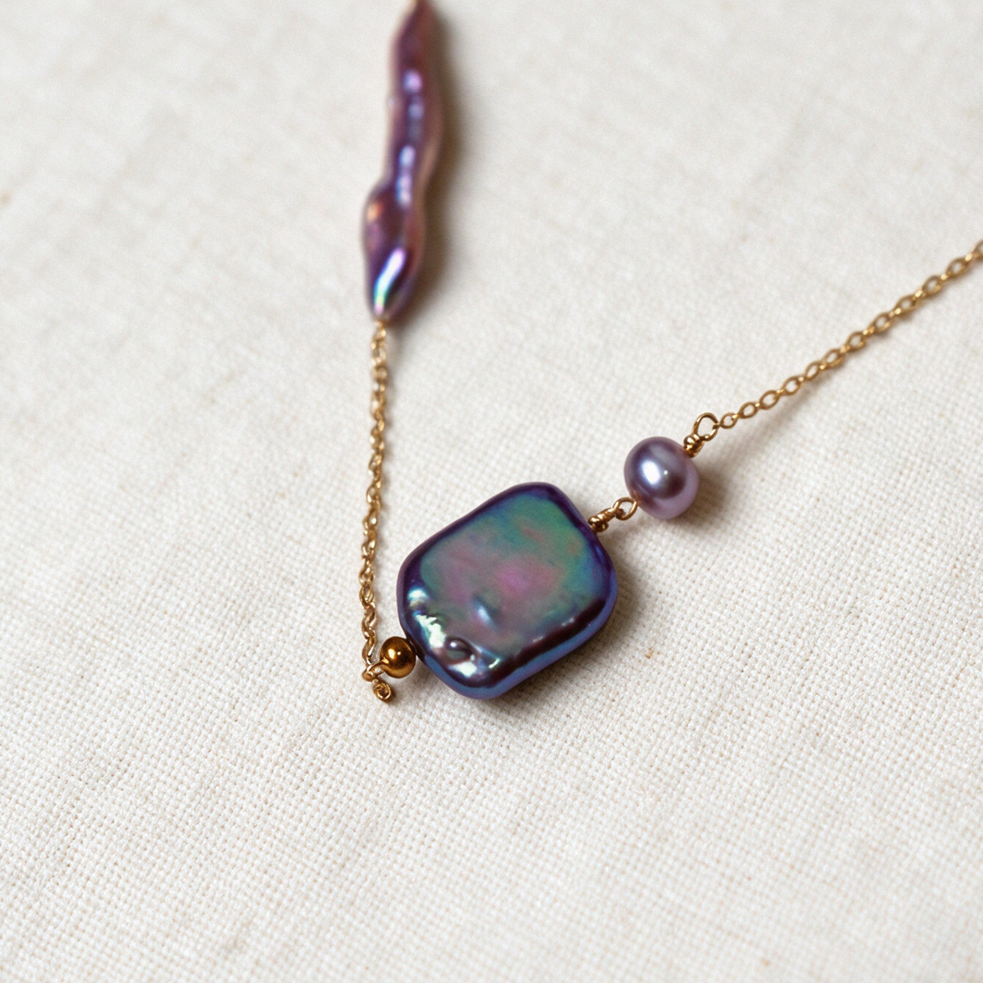 Close-up of the square iridescent baroque pearl and purple tourmaline detail on the Iris Necklace