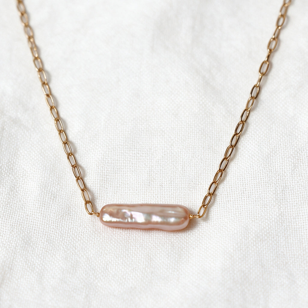 Rosalie Necklace with an elongated blush-pink baroque pearl set horizontally on a 14k gold-filled chain