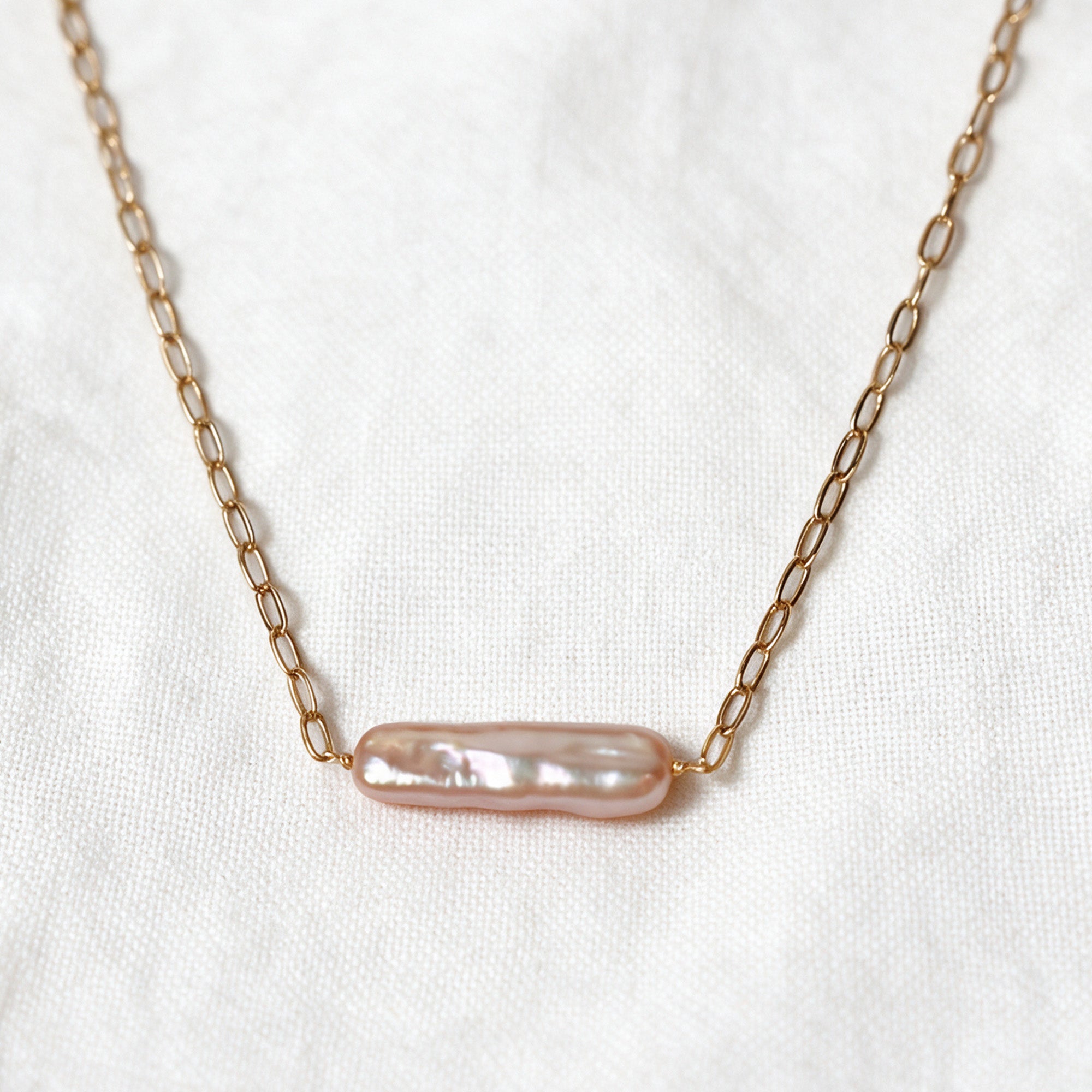 Rosalie Necklace with an elongated blush-pink baroque pearl set horizontally on a 14k gold-filled chain